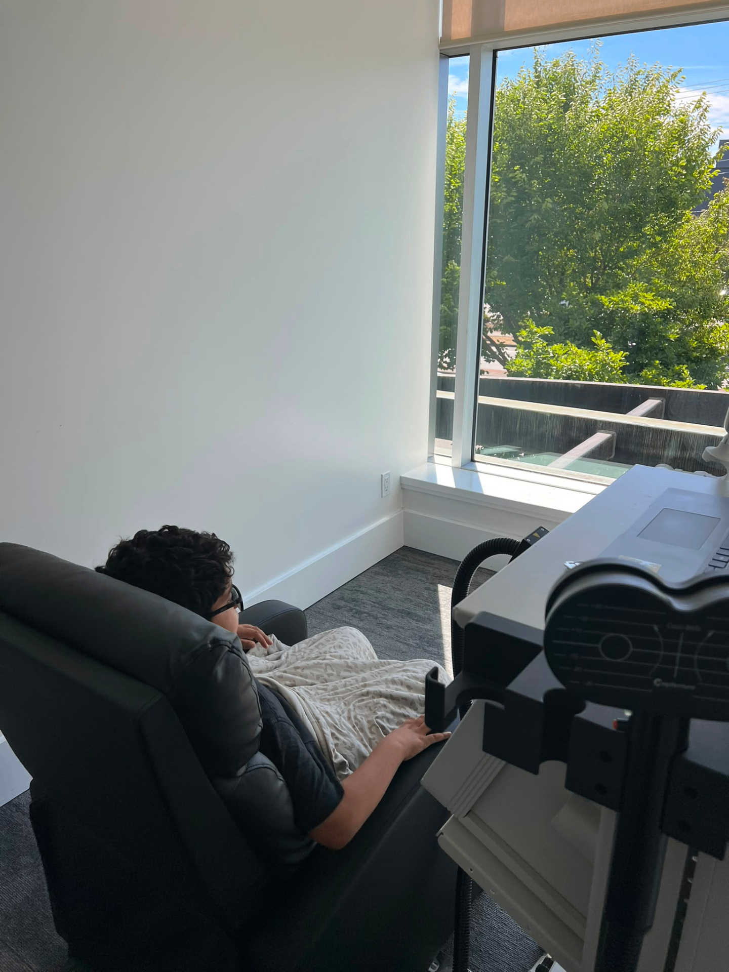 A young patient resting comfortably during a MeRT® session by the window