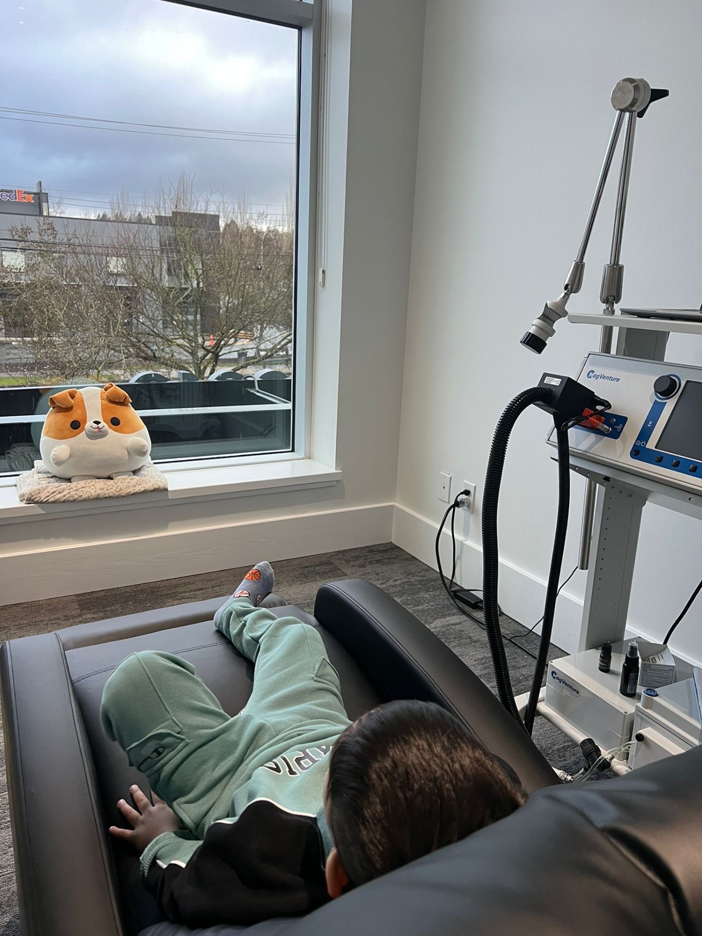 A child resting comfortably during a MeRT® session with a plush toy nearby