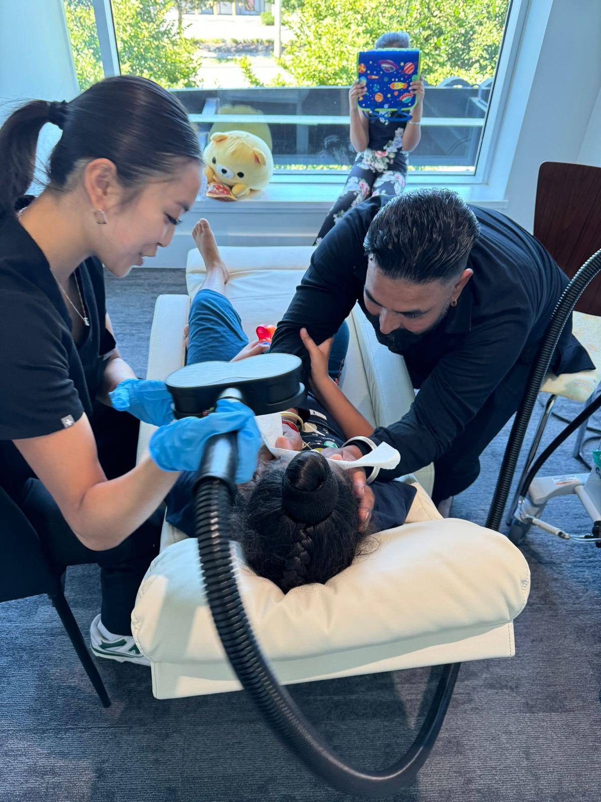 Two clinicians working with a young patient during a calm MeRT® session